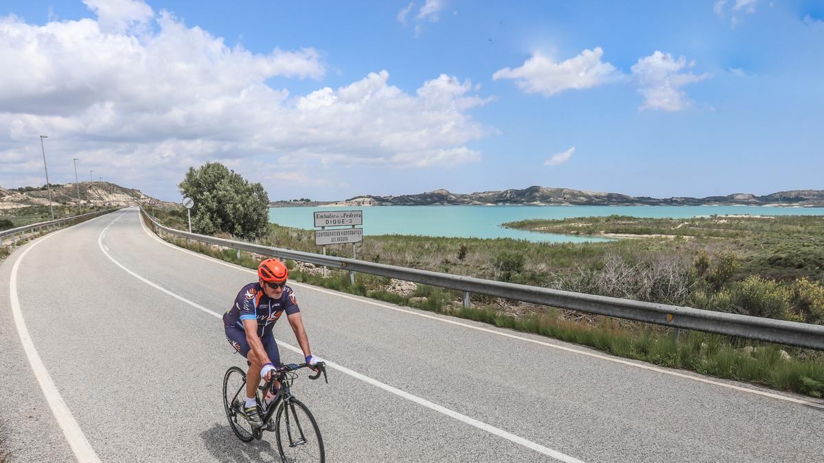 Un ciclista pasa junto al embalse de la Pedrera en la Vega Baja