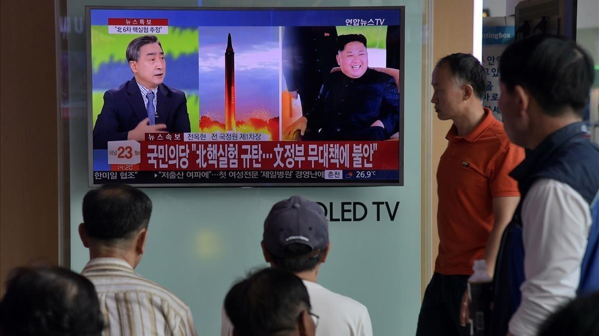 undefined39929866 people watch a television display at a train station in seou170903204227