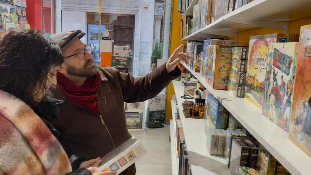 Clients escollint un joc de taula per regalar a La Juganera.