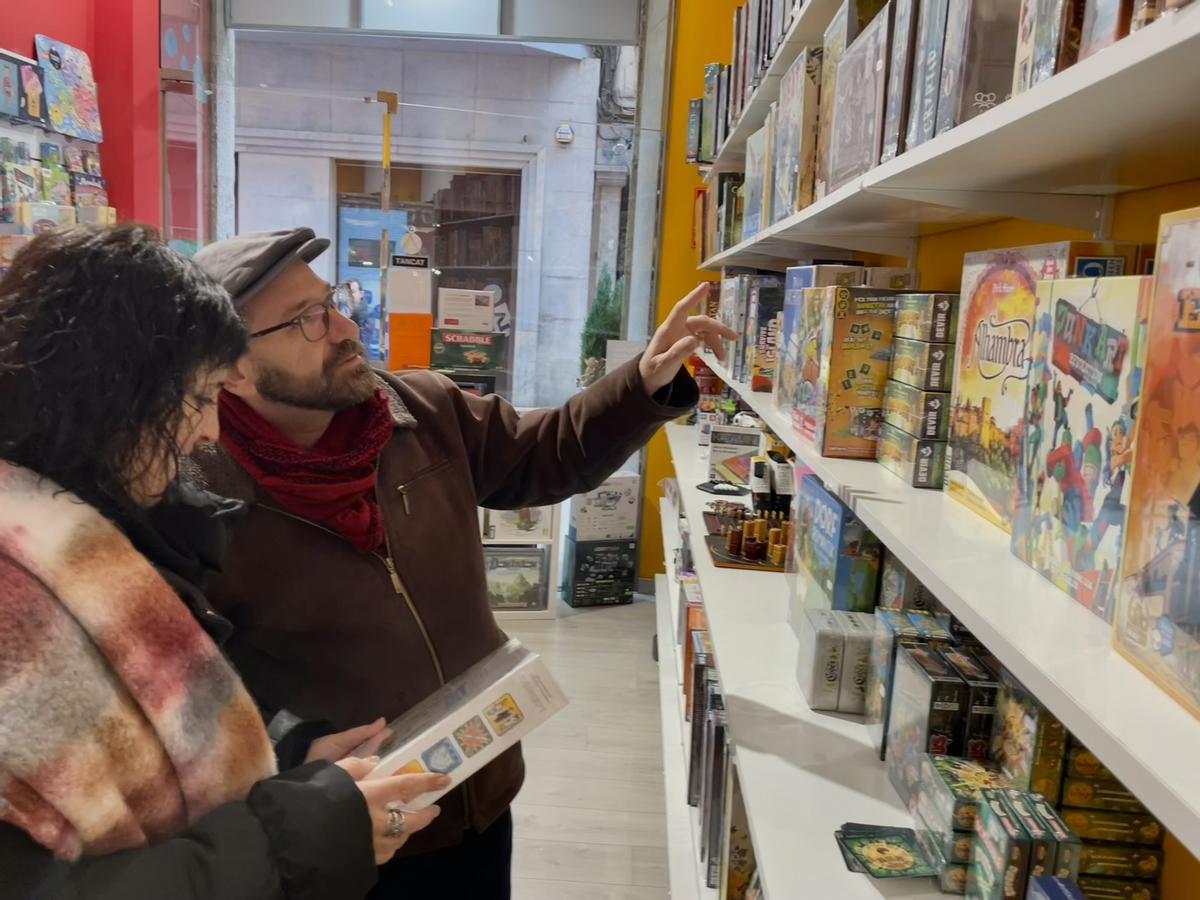 Clients escollint un joc de taula per regalar a La Juganera.