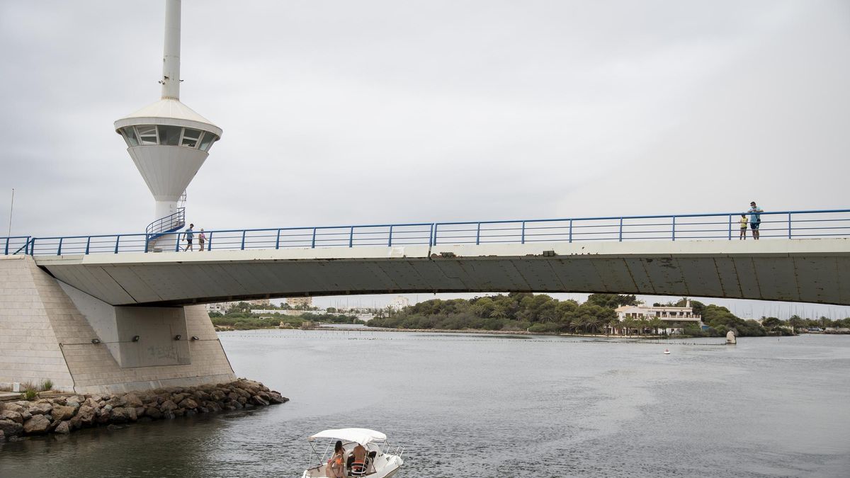 Un pequeño barco cruza por debajo del puente del Estacio, en La Manga del Mar Menor.