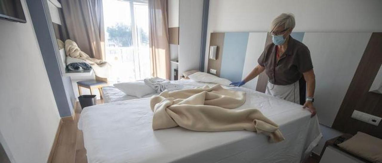 La camarera de piso Presen Alcaraz hace una cama elevable en el Riu Festival, en Platja de Palma.