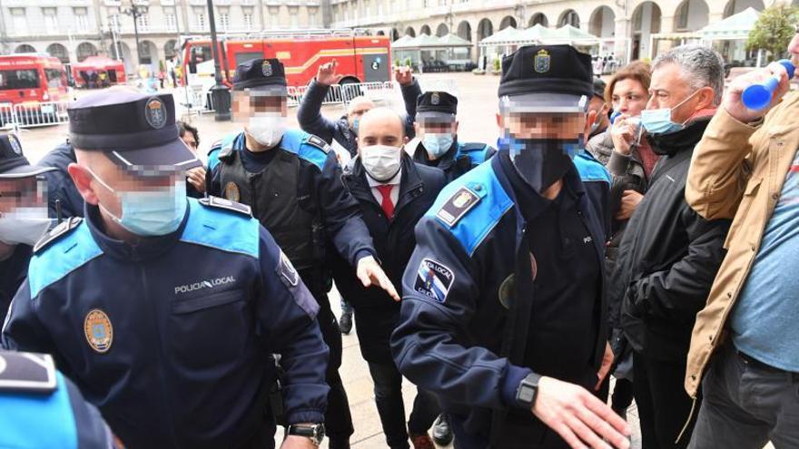 Policías vuelven a proteger a Lage de la protesta sindical del 092. La protesta de policías locales que reclaman mejoras laborales desde hace seis meses en la plaza de María Pita motivó ayer el despliegue de más agentes antes del inicio del pleno. Parte de la decena de efectivos del 092 se encargó de proteger al edil de Facenda e Personal, José Manuel Lage, quien el jueves fue increpado por policías de paisano cuando caminaba por la plaza antes de un pleno extraordinario sobre inseguridad ciudadana. El acoso, con menos manifestantes a su alrededor, se repitió ayer, y Lage fue rodeado hasta por seis agentes. | VÍCTOR ECHAVE