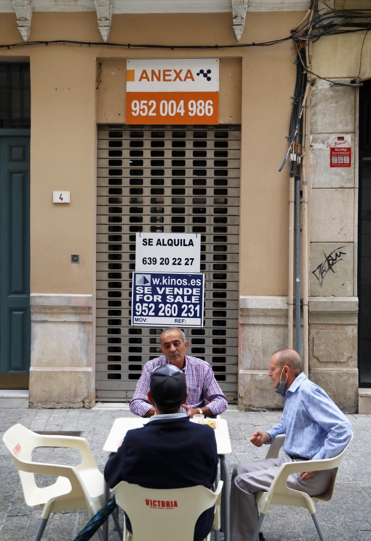 Un cartel de se alquila se lee tras un grupo de comensales.