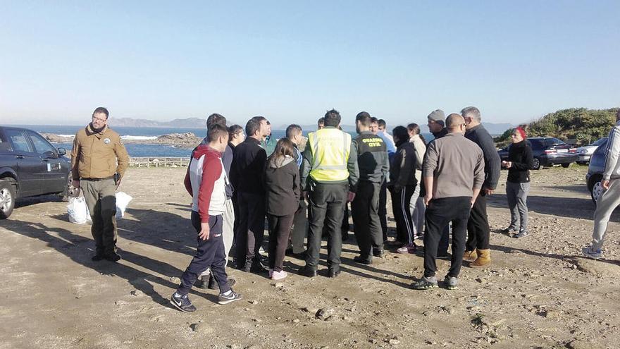 Un guardacostas de la Xunta, con bolsas de percebe decomisado ayer, junto a un grupo de percebeiros denunciando el &quot;atropello&quot; ante dos guardias civiles en Cabo Silleiro.