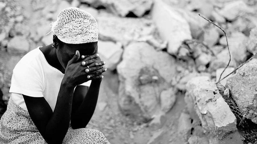 Mujer desolada, entre escombros, tras el terremoto de Haití.  // Reuters