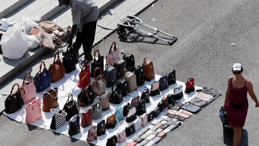 Imagen de archivo de un mantero vendiendo de forma ilegal productos falsificados en Barcelona . EFE/ Andreu Dalmau.