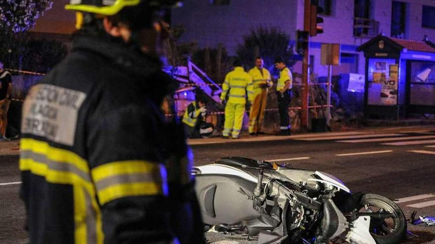 Los servicios de Emergencias ante la moto destrozada en el lugar del accidente. // Iñaki Abella