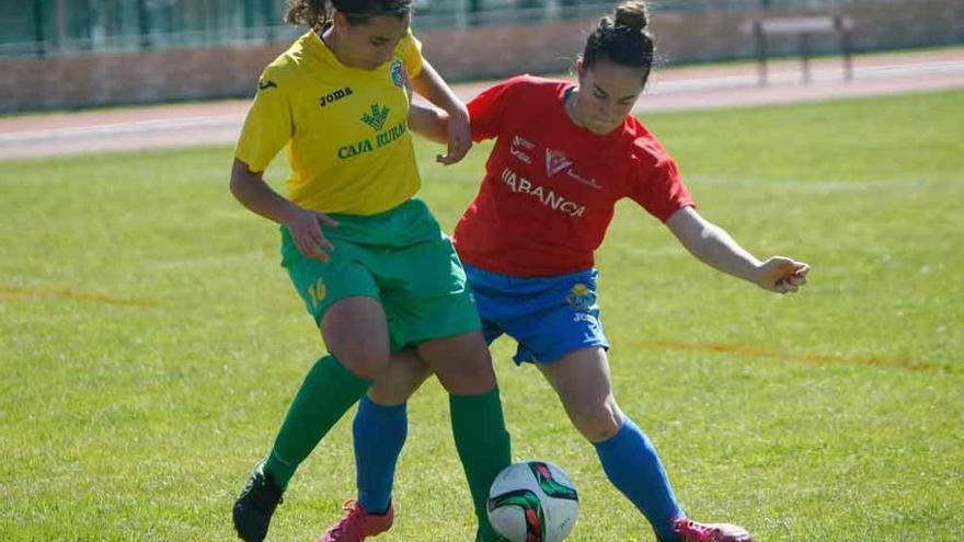 Neli se dispone a despejar el balón ante la presión de una rival.