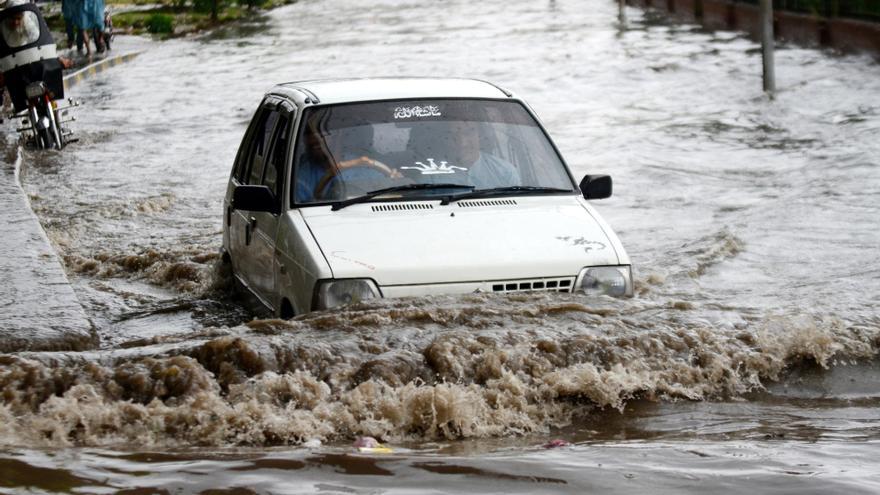 Un coche intenta avanzar en una calle inundada en Pakistán.