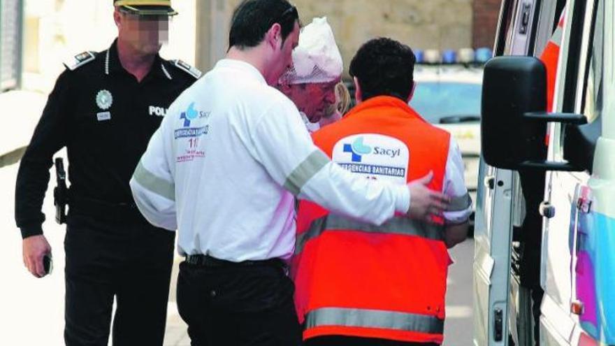 Un vehículo judicial abandona la calle en la que se produjo el suceso. A la izquierda de la imagen, el portal al que accedió el agresor.