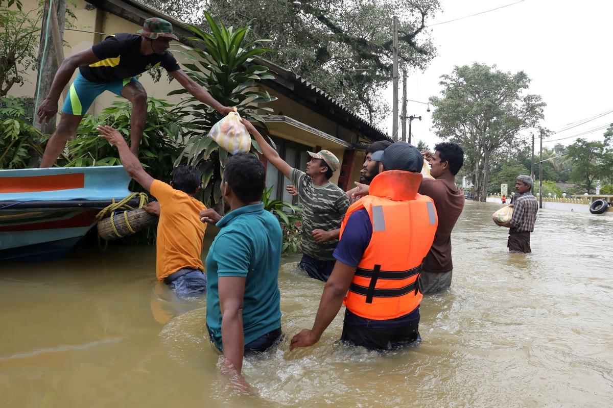 COLOMBO (Sri Lanka), 01/12/2025.- Sri Lanka Civil Defense Force rescue team members distribute dry rations to flood-affected people after heavy rainfall in the suburb of Colombo, Sri Lanka, 01 December 2025. Many parts of the island have been inundated due to heavy rains. According to the Sri Lanka Disaster Management Center, more than 330 people have been killed, and 370 are missing around the country. EFE/EPA/CHAMILA KARUNARATHNE