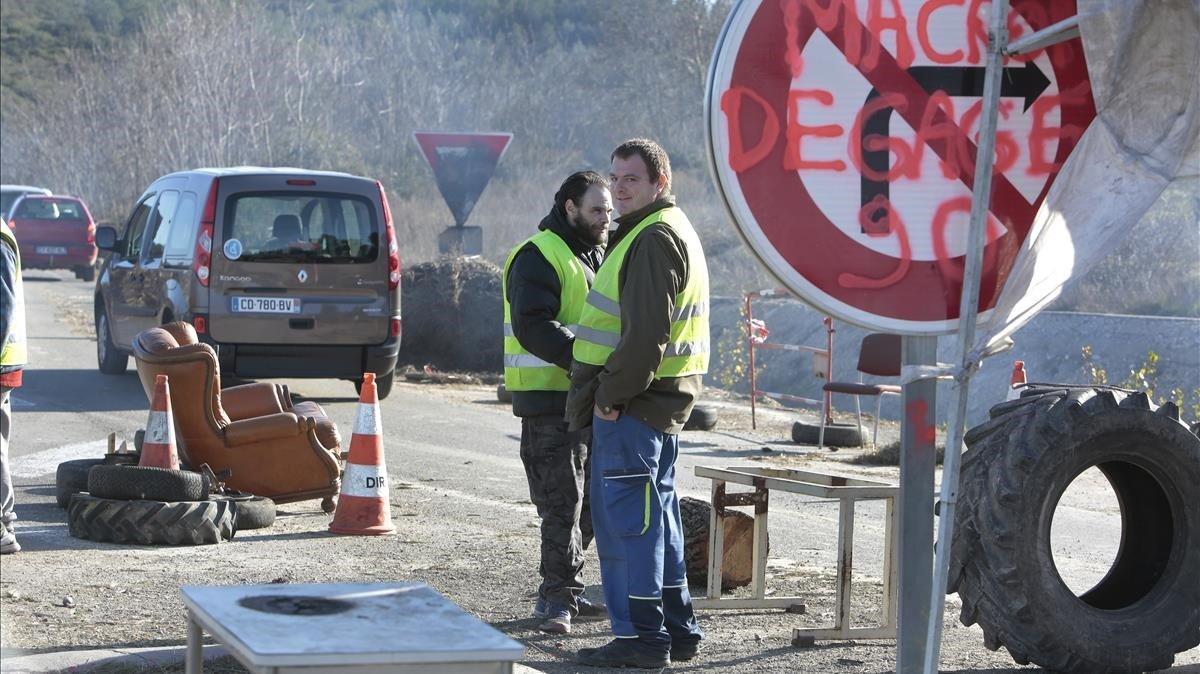 Dos ’chalecos amarillos’ bloquean una carretera en Dions, el pasado martes.