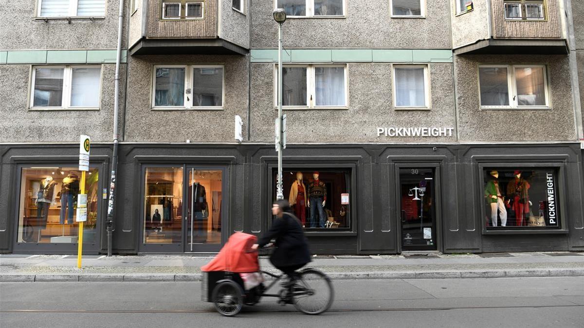 A woman on a bicycle rides past closed shops at the city center  amid the coronavirus disease (COVID-19) pandemic on the days of lockdown in Berlin  Germany  December 17  2020   REUTERS Annegret Hilse