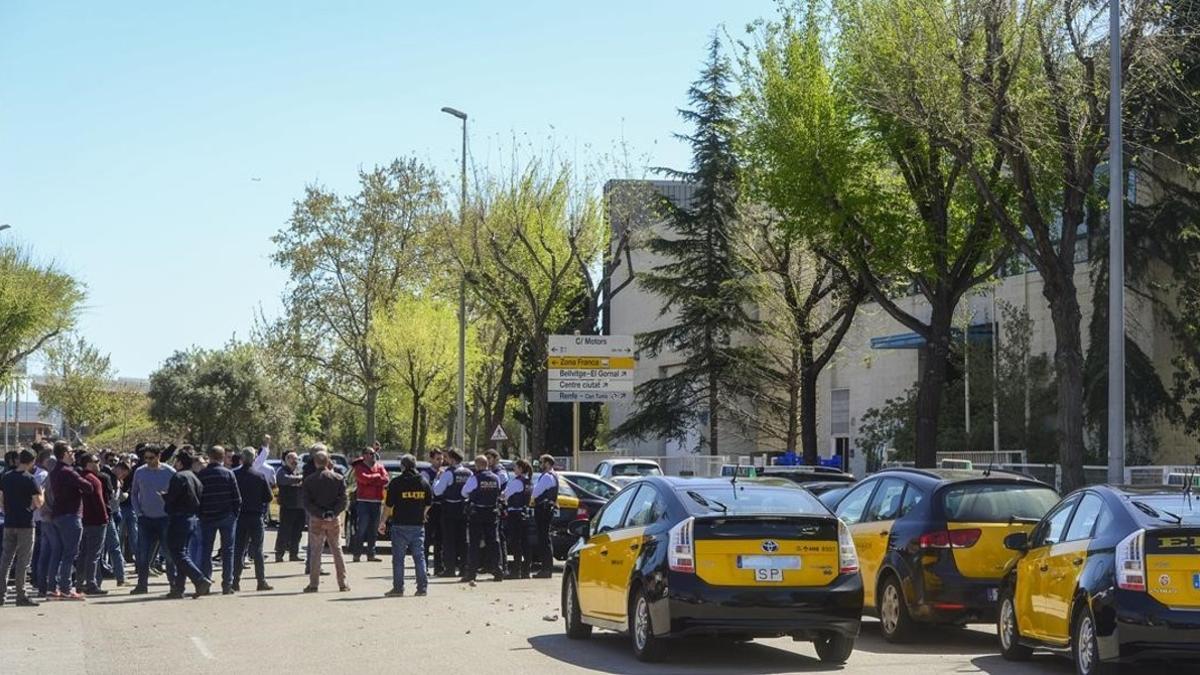 Medio centenar de taxistas se manifiestan contra el intrusismo laboral ante una de la sede de Cabify en L'Hospitalet, una de las empresas que presta servicios de VTC.