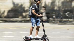 Patinete circulando por la Gran Via, a la altura de la Universitat de Barcelona