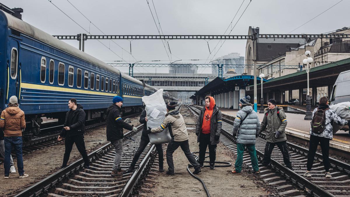 Varios voluntarios transportan ayuda humanitaria en la estación de tren de Kiev.