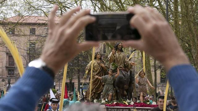 Un hombre hace una foto con el teléfono móvil al paso de La Borriquilla. | M. Fuentes