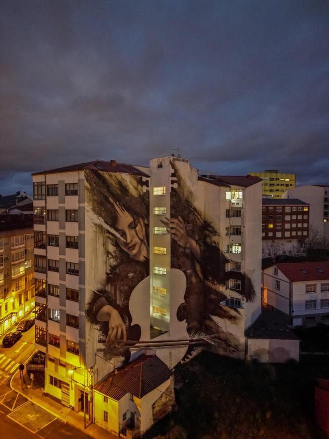 Por la noche, cuando las luces de las casas se encienden, la violonchelista empieza a tocar