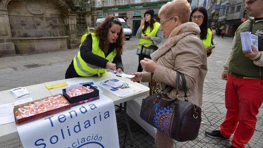 Una voluntaria informa a una mujer en la Praza de A Peregrina. // Gustavo Santos