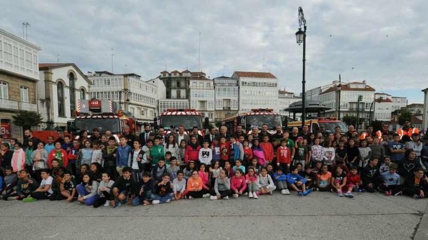 Escolares de Betanzos posan acompañados por los bomberos, responsables provinciales y de Mapfre.