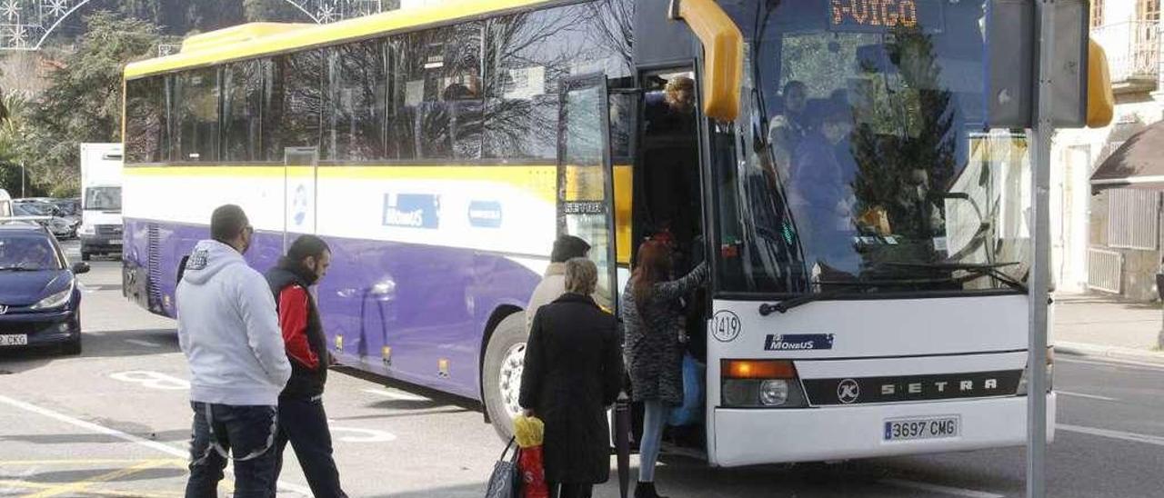 Varias personas toman un autobús en Cangas para desplazarse a Moaña y Vigo. // Santos Álvarez