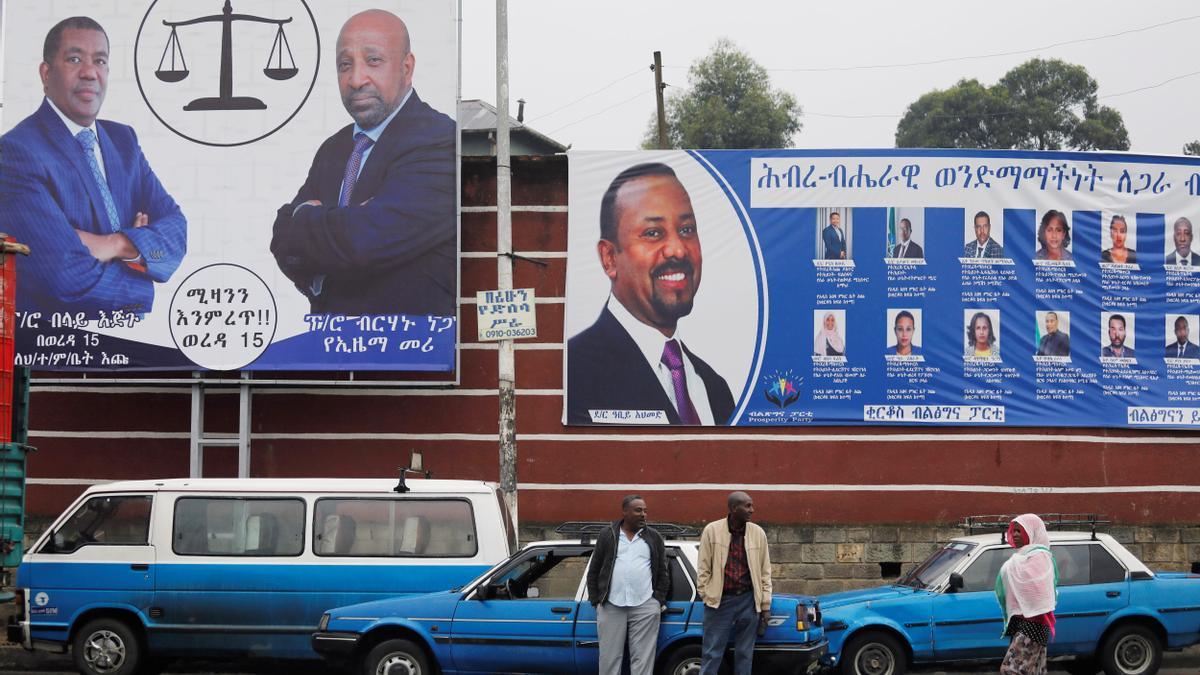 Un grupo de taxistas frente a un cartel el electoral del primer ministroAbiy Ahmed.