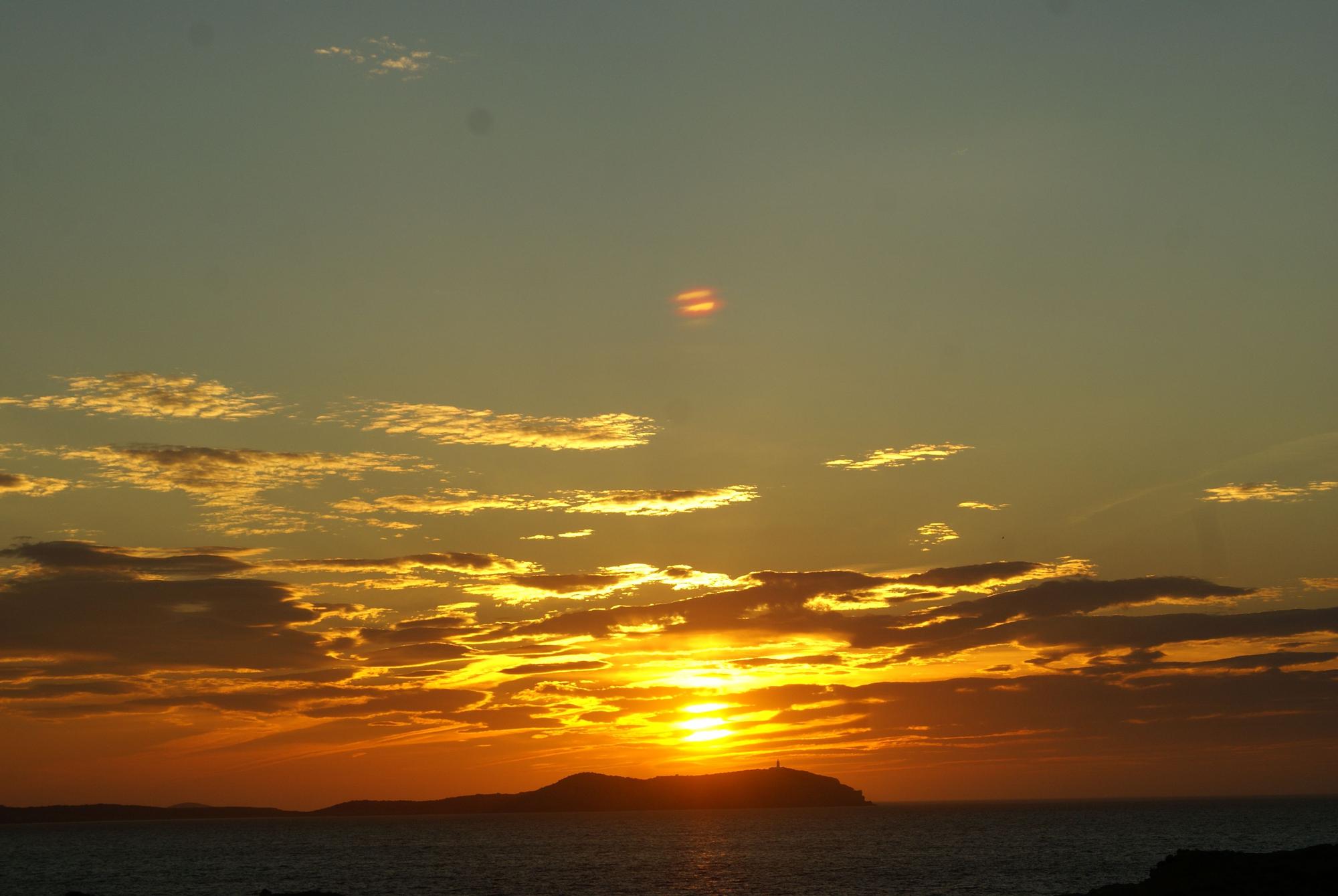 Puesta de sol desde la costa oeste de Sant Antoni con sa Conillera al fondo.