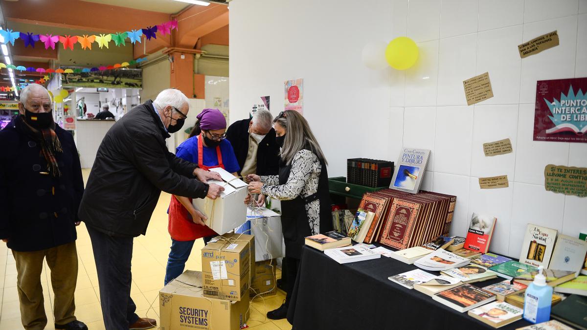 La asociación Intramuros entrega libros para la biblioteca de la plaza de abastos.