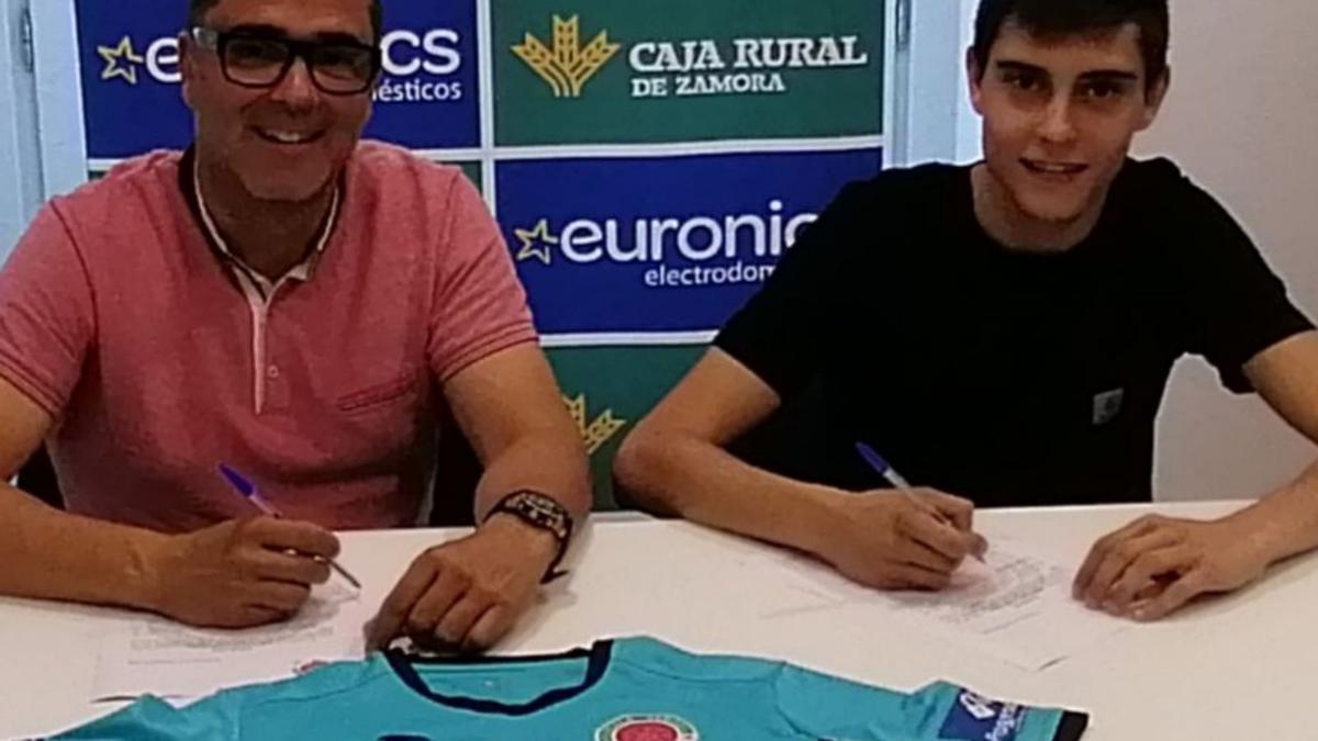 El joven portero firma su contrato con el director técnico Luismi Merchán.