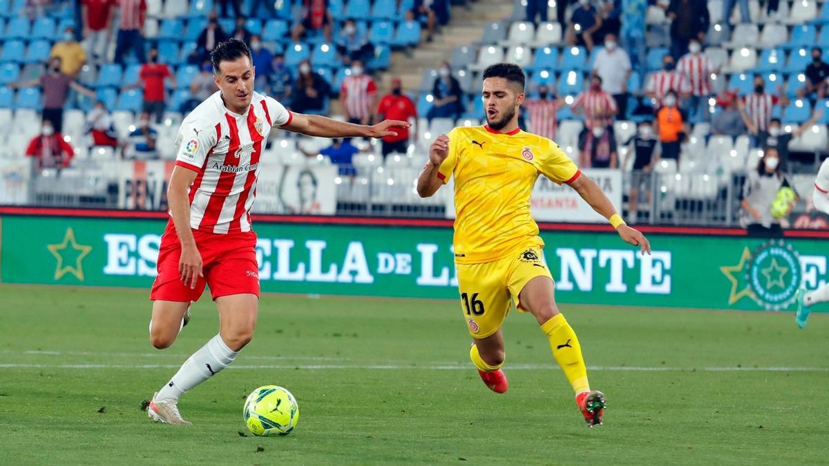 Yan Couto, del Girona, intenta cortar el avance de un jugador del Almería.