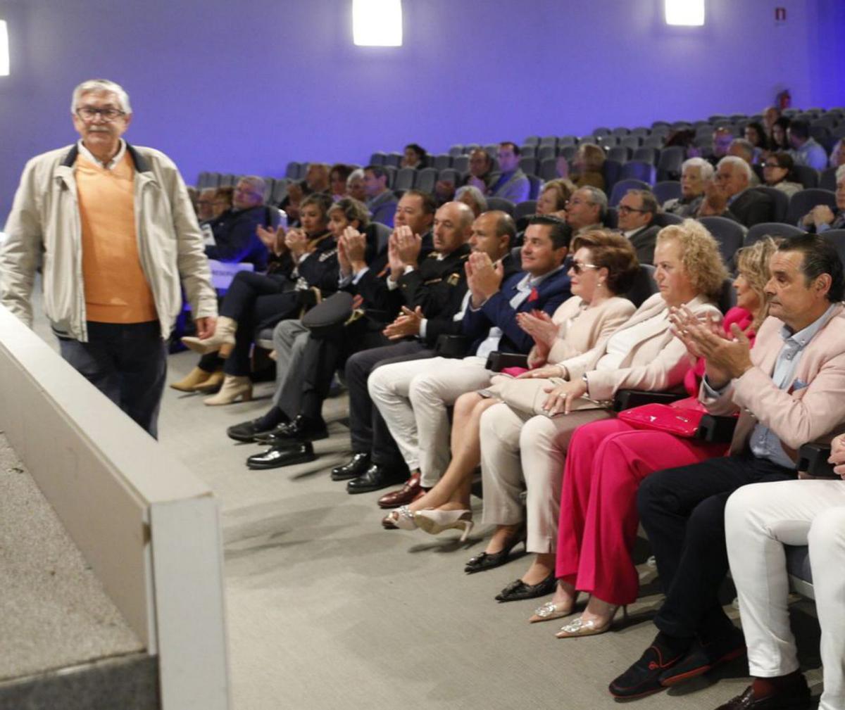 Luis García, líder vecinal de Viesques, yendo a por su premio otorgado por los donantes de sangre, con parte del público asistente a la asamblea. | M. L.