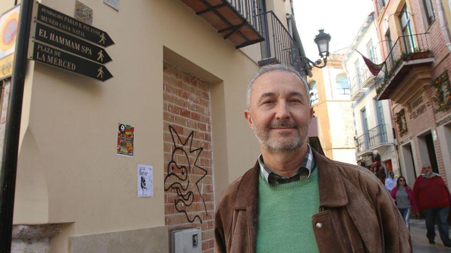 El profesor Francisco Rodríguez Marín, junto a un grupo de señales turísticas en la calle Granada.