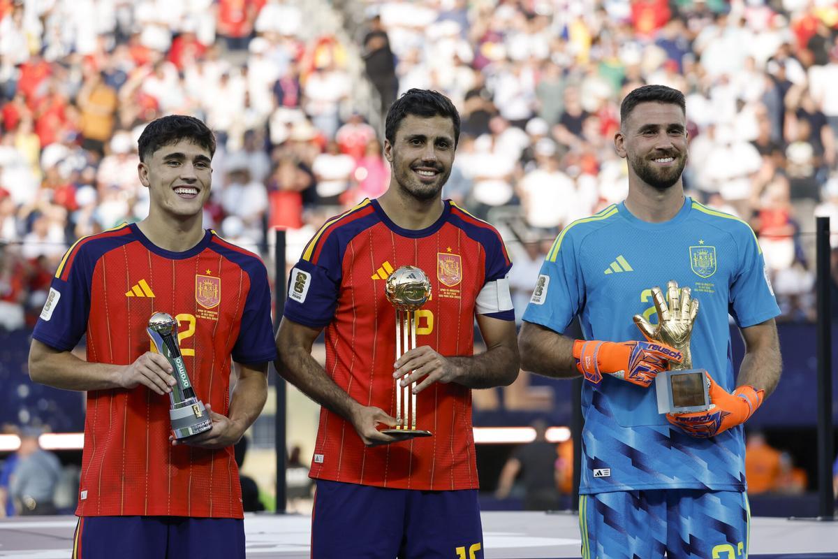 Pau Cubarsí (i), Rodri Hernández (c) y Unai Simón de España posan con sus trofeos en las premiaciones del Mundial de la FIFA 2026 este domingo, tras vencer a Argentina en la final en el estadio MetLife en East Rutherford (NJ, EE.UU.).