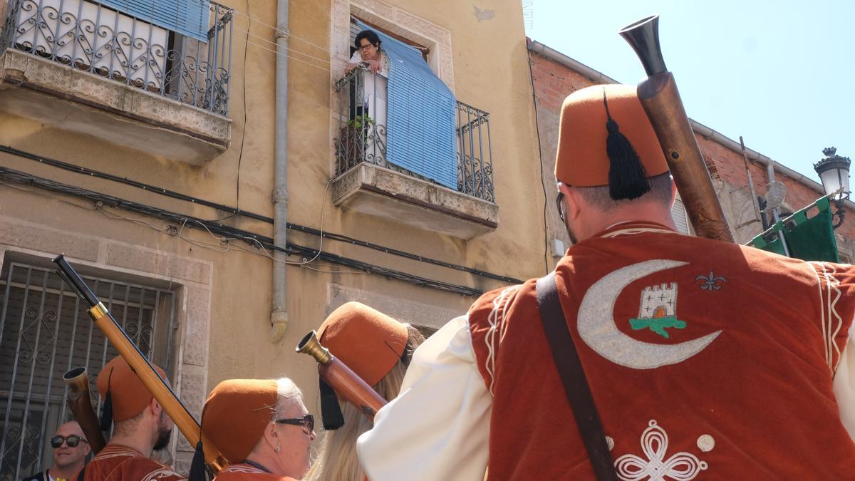 Una mujer presencia el pasacalles de los festeros desde su balcón.