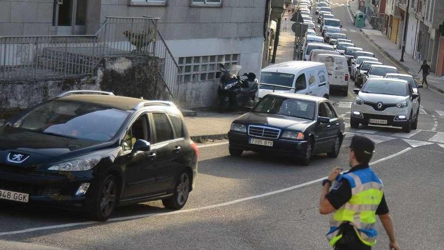 Un agente intenta aliviar el tráfico en al cruce de Vilariño, ayer, a última hora de la tarde. // G. Núñez