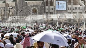 Fieles musulmanes caminan por el complejo de la Gran Mezquita bajo los ventiladores con pulverización de agua instalados en la ciudad santa de La Meca el 24 de mayo de 2026, antes de la peregrinación anual del hach.