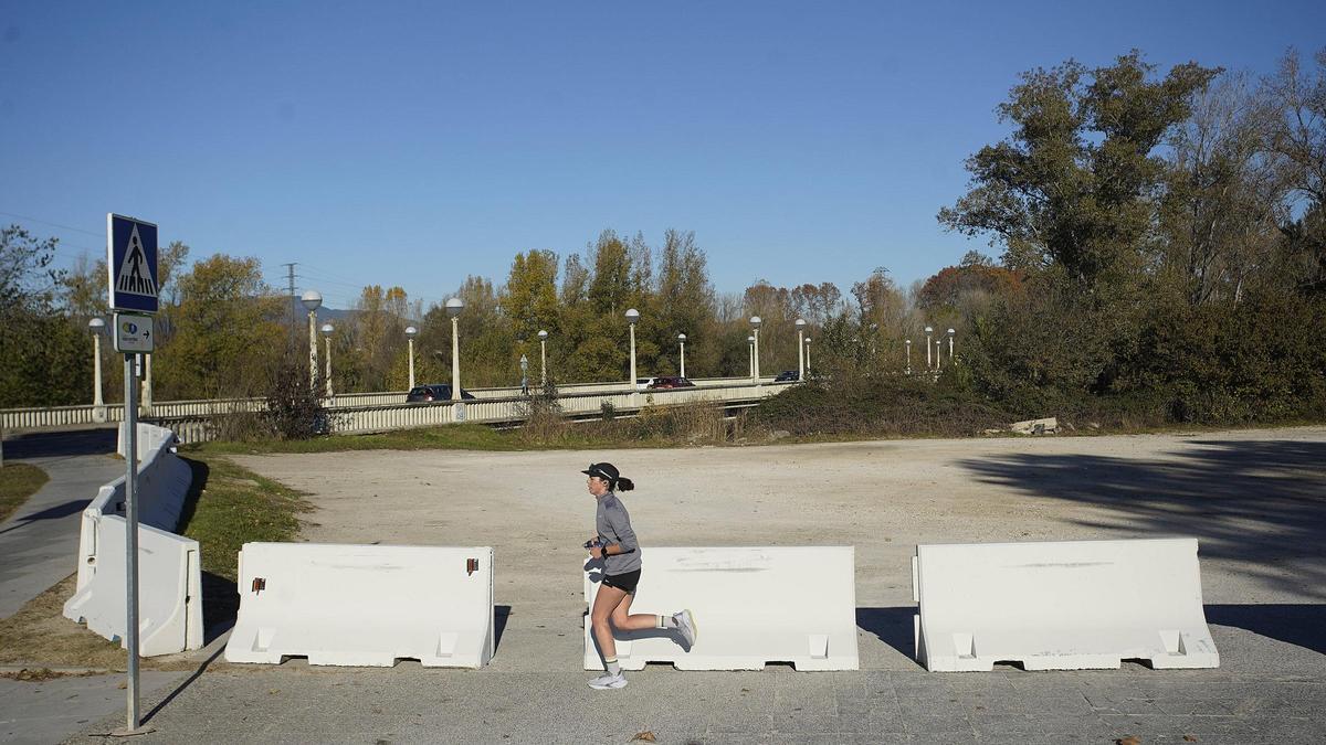 Una noia pasa corrent pels blocs de forimgó que encerclen el terreny en sisputa.