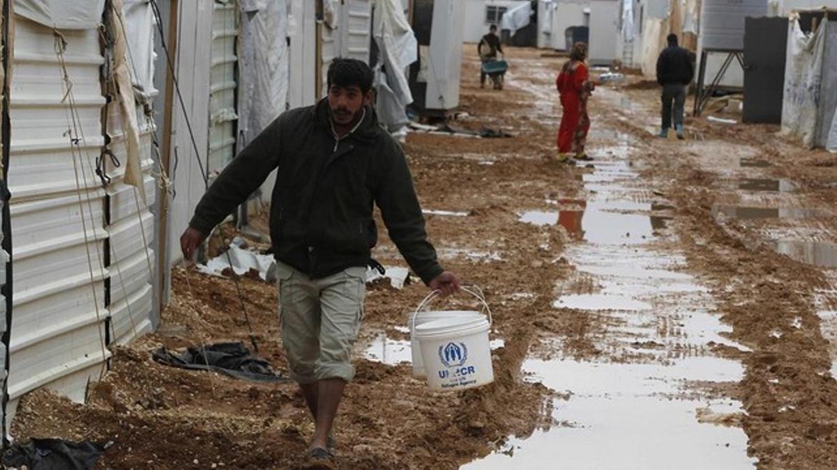 Refugiados sirios en el campo de Al Zaatari (Jordania) que la lluvia ha convertido en un barrizal.