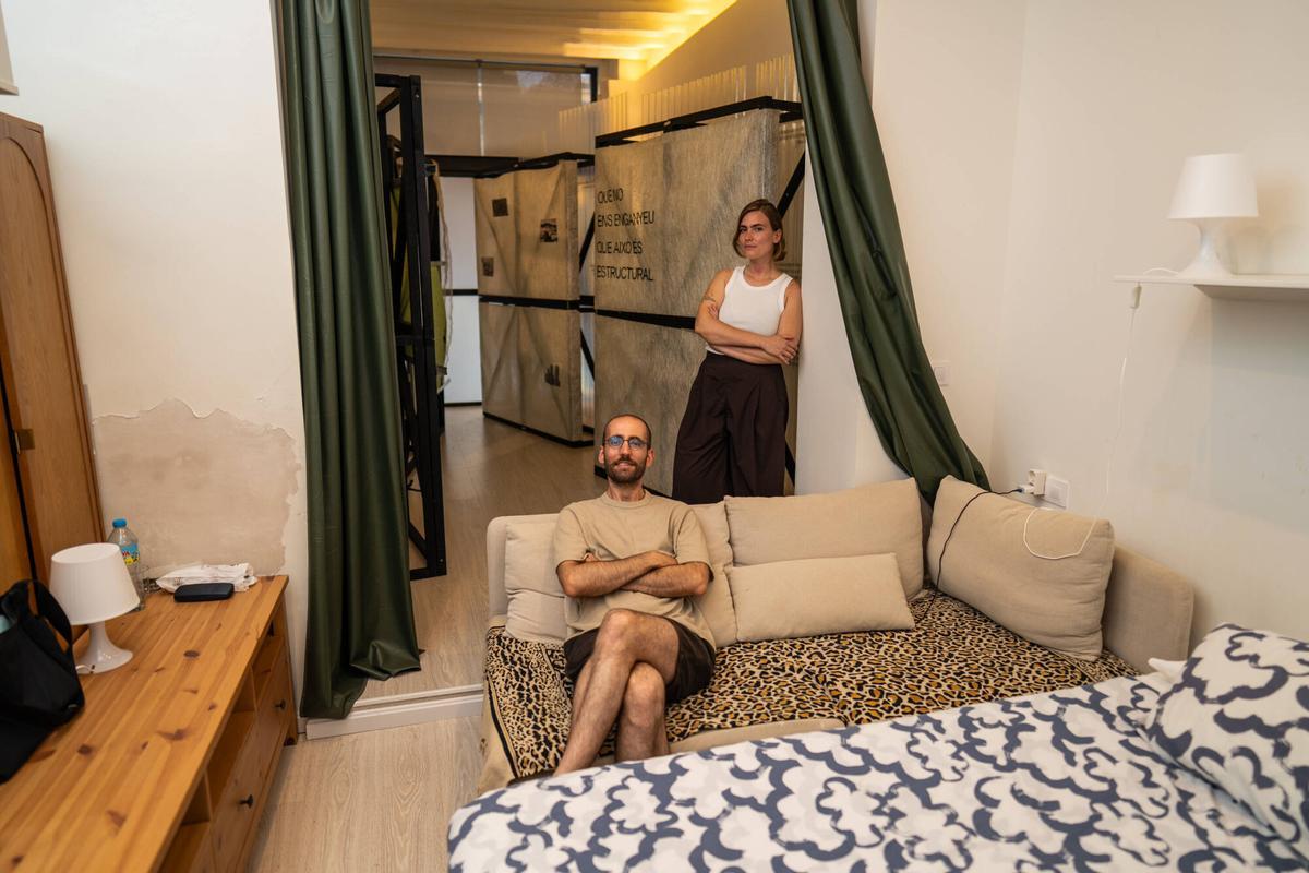 Barcelona. Iris Verge, comisaria y artista, y Miquel Hernández, historiador y artista, organizadores del proyecto Todo podría ser diferente ('Tot podria ser diferent'), posan en un piso turístico ilegal del barrio del Raval donde han instalado una exposición para denunciar la crisis de la vivienda. 29 de junio de 2026. Cultura. AUTOR: ZOWY VOETEN