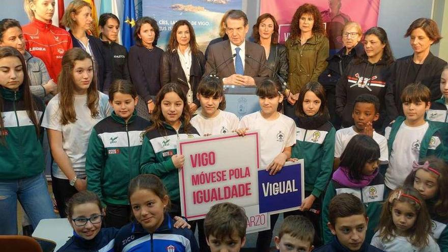 El alcalde Abel Caballero rodeado de deportistas femeninas durante la presentación de la marcha. // FdV