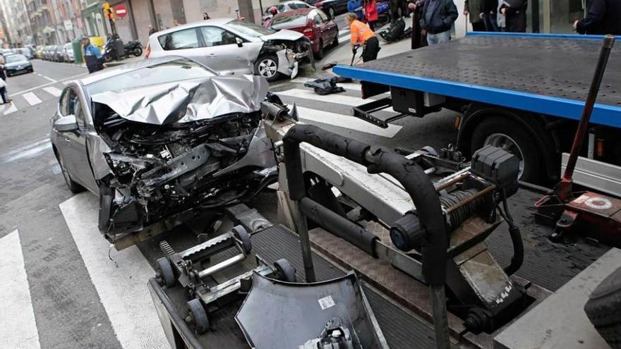 La grúa retira uno de los coches implicados en el suceso.