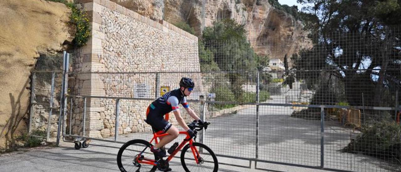 Un ciclista da la vuelta tras llegar a la valla que desde 2017 impide el paso al santuario.