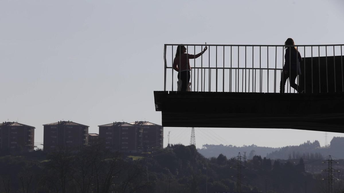Caminantes en la pasarela peatonal al Centro Niemeyer.