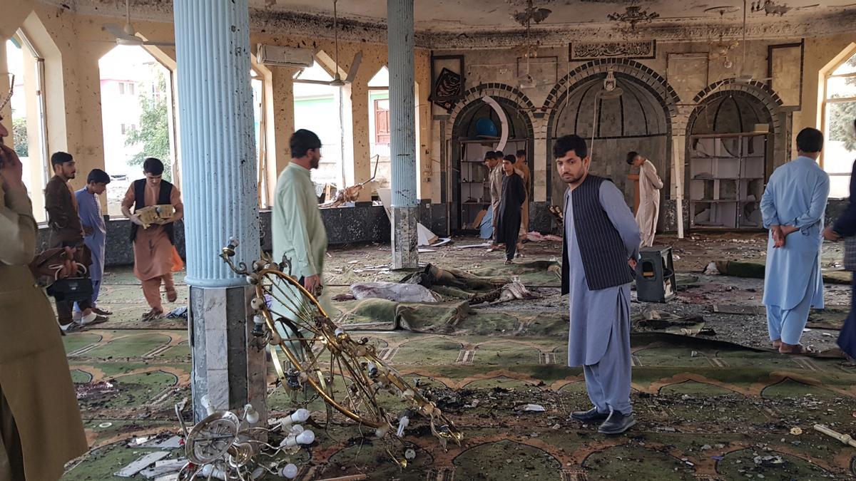 Un grupo de afganos inspeccionan el interior de la mezquita atacada en Kunduz, este viernes.