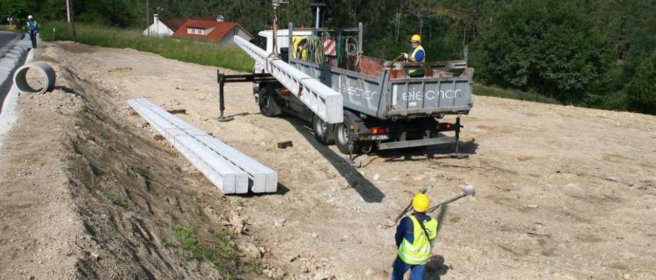 Llegada, en la mañana de ayer, de los nuevos postes para el retranqueo de la línea. // Bernabé/Víctor Espiño