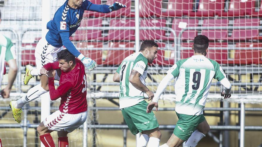 El meta Iván Crespo sale a despejar un balón, mientras su compañero Pumar lo estorba desde el suelo