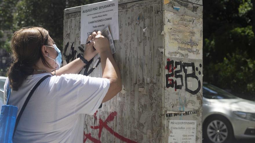 Una mujer se apunta un teléfono de un piso de estudiantes en alquiler. | JOSÉ MANUEL LÓPEZ