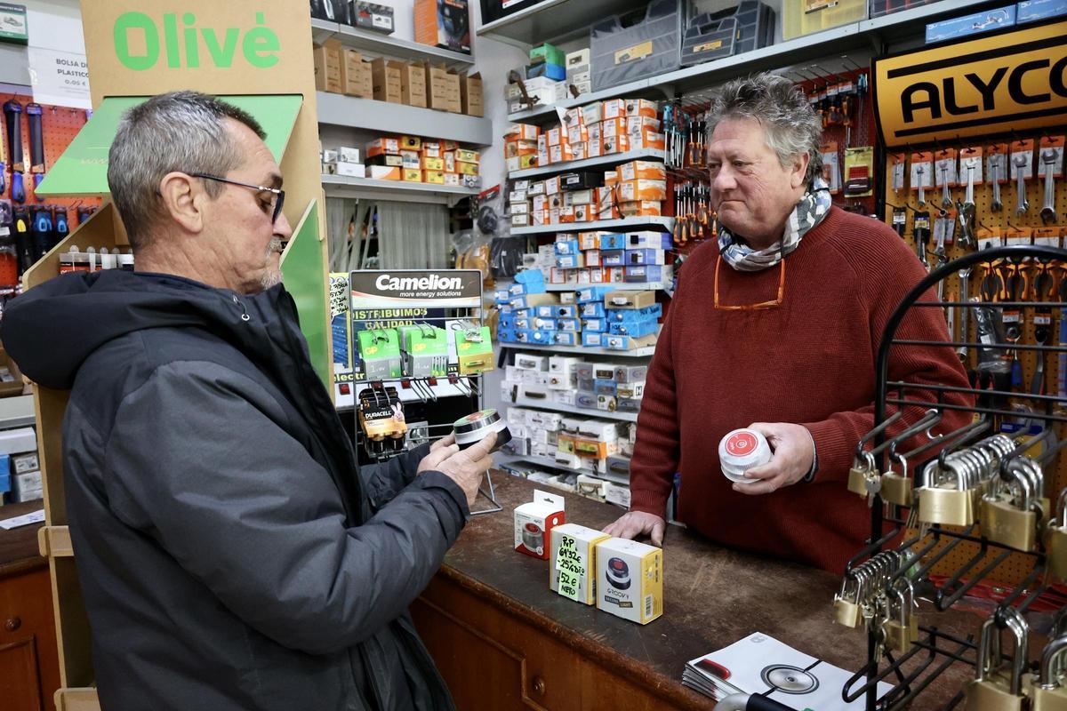 Un hombre sostiene en su mano una baliza de las nuevas que desde el 1 de enero son obligatorias, este viernes en la ferretería Parra en Murcia.
