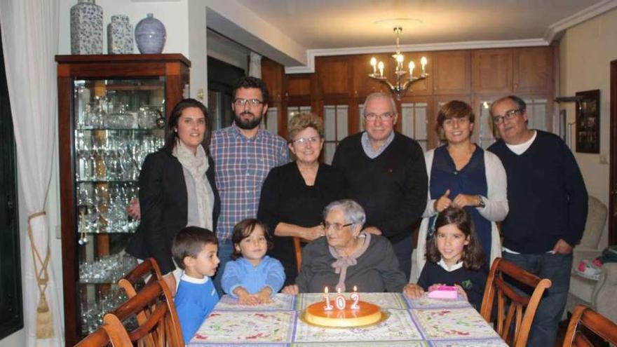 Elisa Antela sopla las velas en su 102 cumpleaños en casa arropada por su familia. // D.P.
